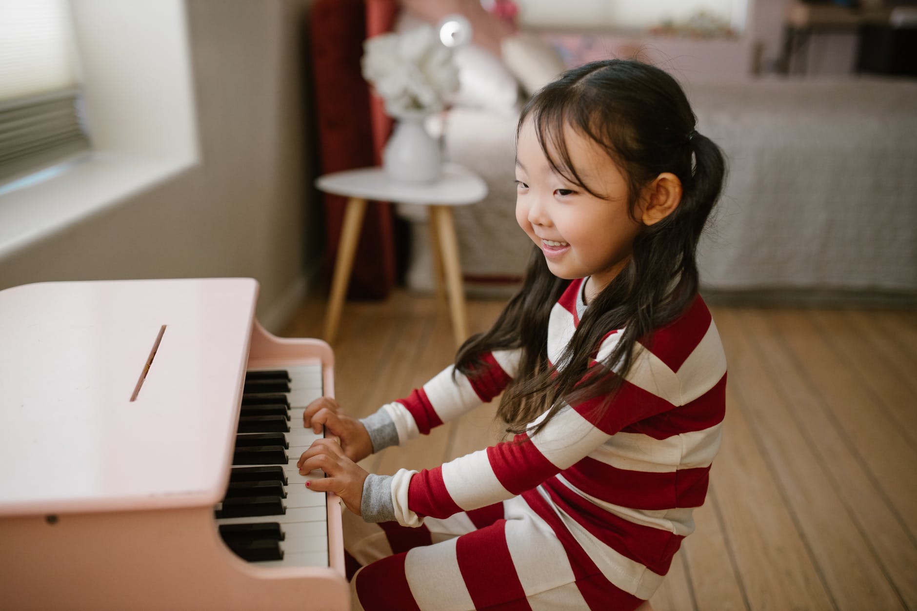 smiling child playing toy piano
