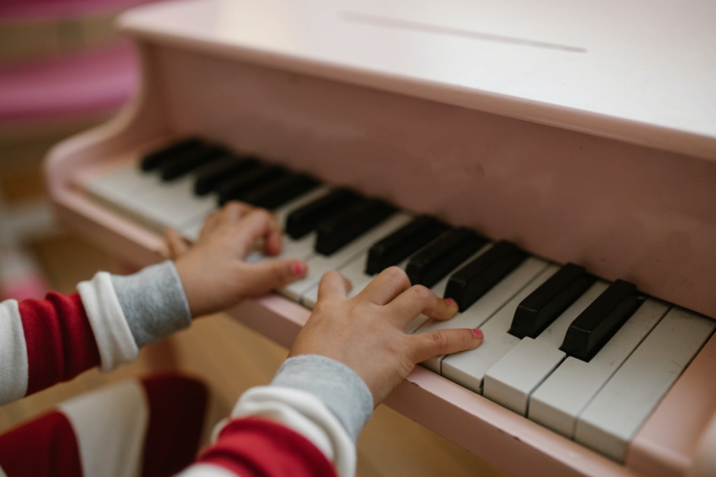 close up on child hands on toy piano