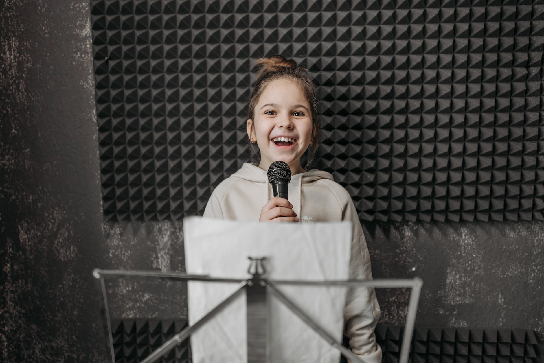 kid holding a microphone inside a music studio